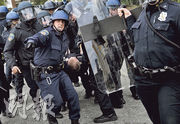 巴爾的摩騷亂造成多人受傷，有警員周一將受傷的同僚抬走治理。（法新社）