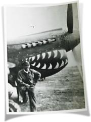 廖譚清在以鯊魚牙塗裝在機首的飛虎隊P-40戰鬥機前留影。（受訪者提供）