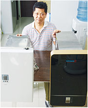 「香港熱泵」主席陳世光表示，該公司自行研發的空氣能熱水器（右），從前面看來，已和一般煤氣熱水器（左）的大小相若，只是長度較長。
