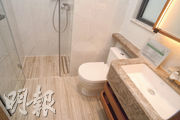 浴室採用淋浴間設計，洗手盆則選用淺灰色石材。