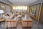 長方形的客廳放置米色梳化及茶几，外連94方呎露台。