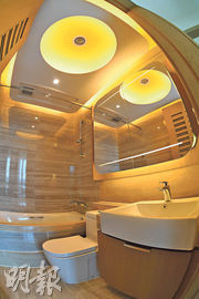 浴室以淺木色為主調，備有鏡櫃、暖燈、浴缸等設備。