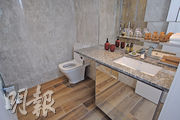 浴室空間寬敞，牆壁以石材鋪砌，品牌洗浴用品齊備。