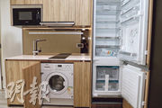 廚房採開放式設計，配備電磁爐、雪櫃、洗衣及乾衣機等品牌家電。（鍾林枝、林靄怡攝）
