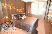 主人睡房以深色為主調，灰銀色寢具配以金色手繪圖案的波浪牆身，氣派十足。（劉焌陶攝）