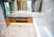 主人浴室由白色石材鋪砌，設有雙面盆、企缸和浴缸，亦有天窗可引入自然光。（劉焌陶攝）