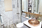 浴室採用白色石材，金色洗手盆顯得份外搶眼。（朱安妮攝）