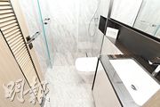浴室地板和牆身均以灰白色石材鋪砌，設有淋浴間及雙門鏡櫃。（劉焌陶攝）