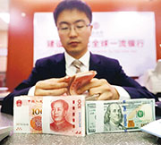 美國聯儲局上周四透露更新貨幣政策聲明，美匯指數昨跌穿92點，帶動亞洲區貨幣兌美元上升，人民幣昨一度升穿6.82。圖為內地銀行工作人員清點貨幣。（資料圖片）