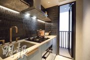 廚房深色磚牆與淺色櫃互相映襯，空間充裕，且附設工作平台。