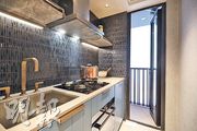 廚房深色磚牆與淺色櫃互相映襯，空間充裕，且附設工作平台。（曾憲宗攝）