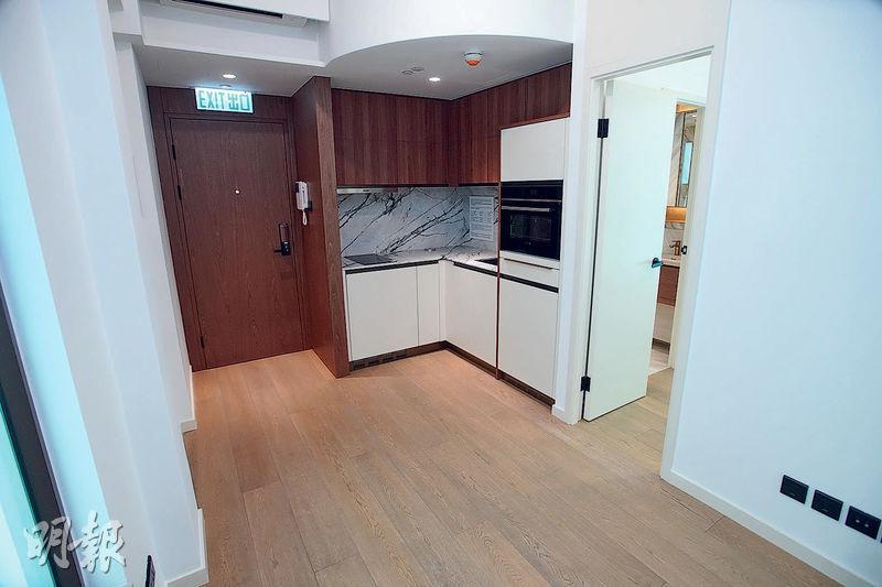 1房單位設有開放式廚房，以啡木色及白色為主色調，另外亦附有西門子的廚房電器。