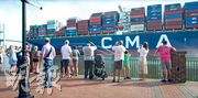 喬治亞州薩凡納旅遊業界人士表示，擠塞的美國第四大港口薩凡納，吸引更多遊客到當地觀看貨櫃船進出的場面。圖為最大貨船進入薩凡納港口時，群眾於岸邊拍照。