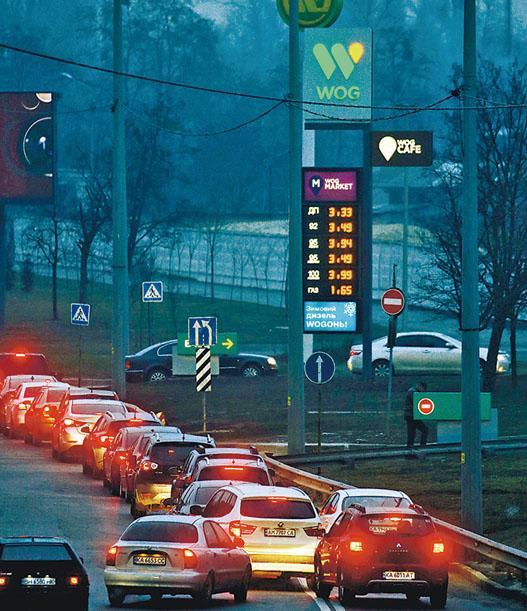 俄烏開戰後，烏克蘭基輔一間油站外，大批車輛排隊入油。（路透社）