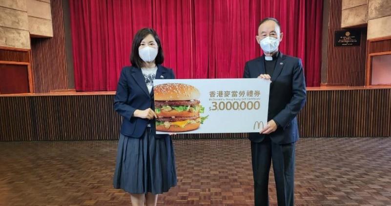 香港麥當勞行政總裁黎韋詩女士(左)向香港明愛捐出港幣300萬餐券，並由香港明愛總裁閻德龍神父(右)代表接收