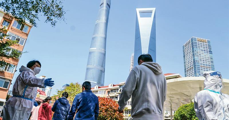 上海最初堅持不封城，目前也要全城封控。有投行指，上海為中國主要金融、商業和貿易中心，若封城持續，上海4月GDP將損失6%，全國則損失2%。圖為上海浦東區，市民排隊準備檢測。（新華社）