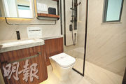 浴室以玻璃趟門設計，設備齊全，包括空氣淨化機、直立式吹風機架等。