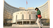 人行決定於2023年3月27日降低金融機構存款準備金率0.25個百分點（不含已執行5%存款準備金率的金融機構）。本次下調後，金融機構加權平均存款準備金率約為7.6%。圖為市民經過位於北京的中國人民銀行。（中新社）