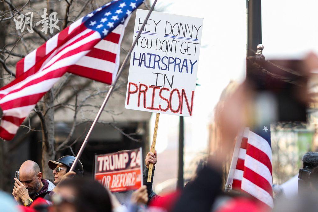 曼克頓刑事法院外，特朗普反對者手持的標語寫着「特朗普，監獄裏沒有髮膠」。（路透社）