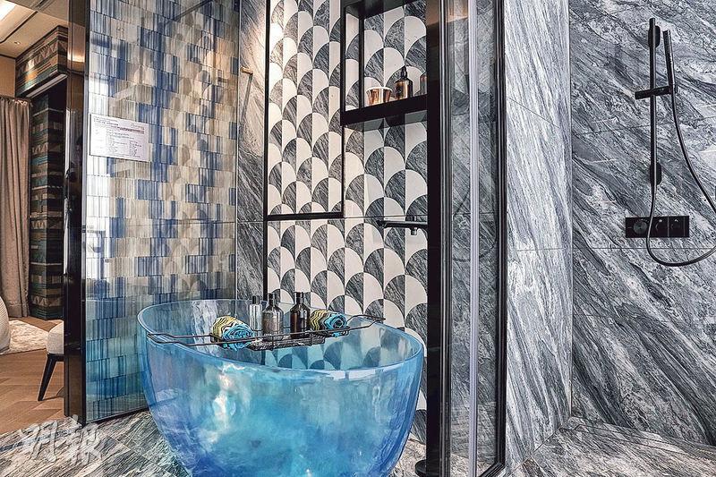 主人浴室設計時尚，採特色雲石牆之餘，更罕有地採用藍色透明橢圓形浴缸。