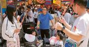 中國4月零售銷售按年上升18.4％，其中餐飲收入按年上升43.8%。圖為遊客在上海南京東路步行街品嘗美食。（中新社）
