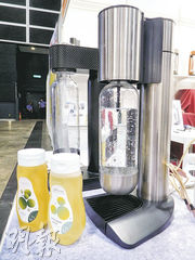 1001HK公司從內地引入一款家居自製梳打水機（右）來港銷售，還順道銷售濃縮果汁（左），希望兩者相輔相成，發揮協同作用。（薛偉傑攝）