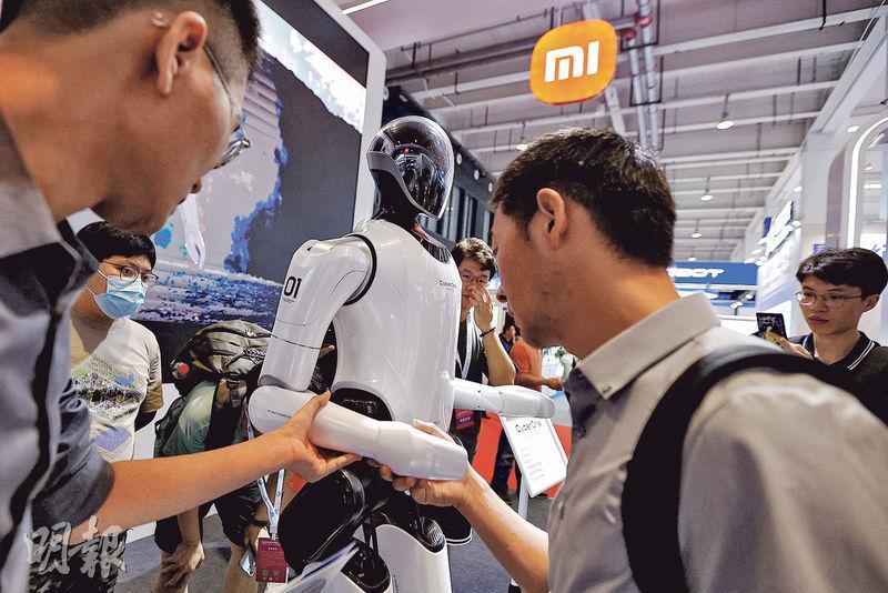 小米上季純利升164.7%至36.7億元，每股基本盈利0.15元。圖為月中於北京舉行的 2023 年北京世界機器人大會上，參觀者觸摸小米開發的人形機器人 Cyber​​One。（路透社）