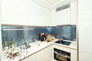 開放式廚房設備齊全，牆身的水紋玻璃飾面，配合全屋設計主調，美觀亦實用。