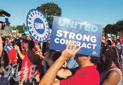 圖為美國汽車工人聯合會（UAW）的成員，在本周一（4日）美國勞動節假期於底特律參與遊行，呼籲工人團結爭取權益。UAW正與美國3大車廠商討新的勞工協議，為工人爭取至少四成的加薪幅度。（法新社）