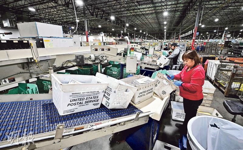 圖為美國洛杉磯的郵政工人處理包裹。美國11月失業率降至3.7%，是7月以來最低，逆轉了美國勞動力市場此前開始放緩的趨勢。（法新社）