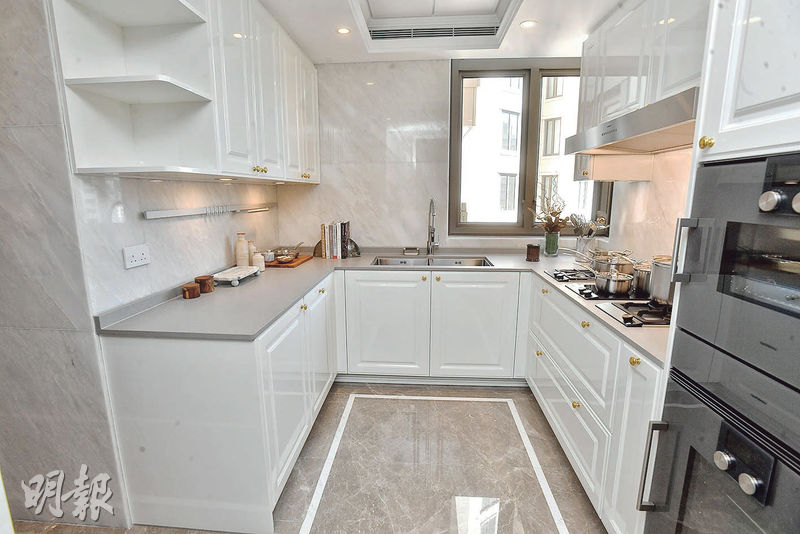 廚房配備白色櫥櫃及灰色雲石地磚，主要工作位置呈U形設計。（劉焌陶攝）