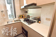 廚房呈曲尺形設計，配置名牌家電，櫥櫃收納空間不俗。