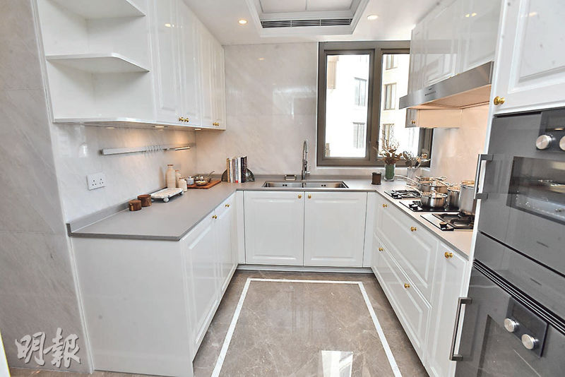 廚房配備白色櫥櫃及灰色雲石地磚，主要工作位置呈U形設計。