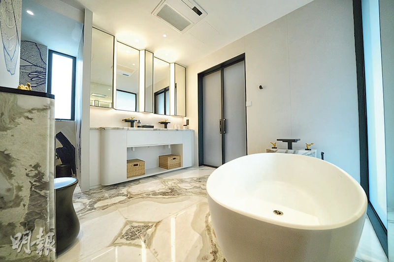 主人套廁配有巨型浴缸及鏡櫃，加以淺色雲石地板及黑色浴室設備，呈現對比效果。（黃志東攝）
