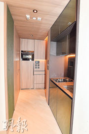 開放式廚房位於大門通往客廳的位置，及大門另一側的大櫃，配備齊全電器。