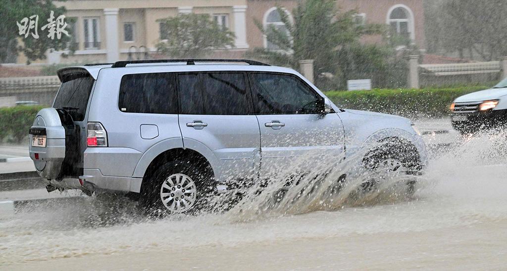 4月16日，迪拜有道路被淹，有車輛涉水而行。（法新社）