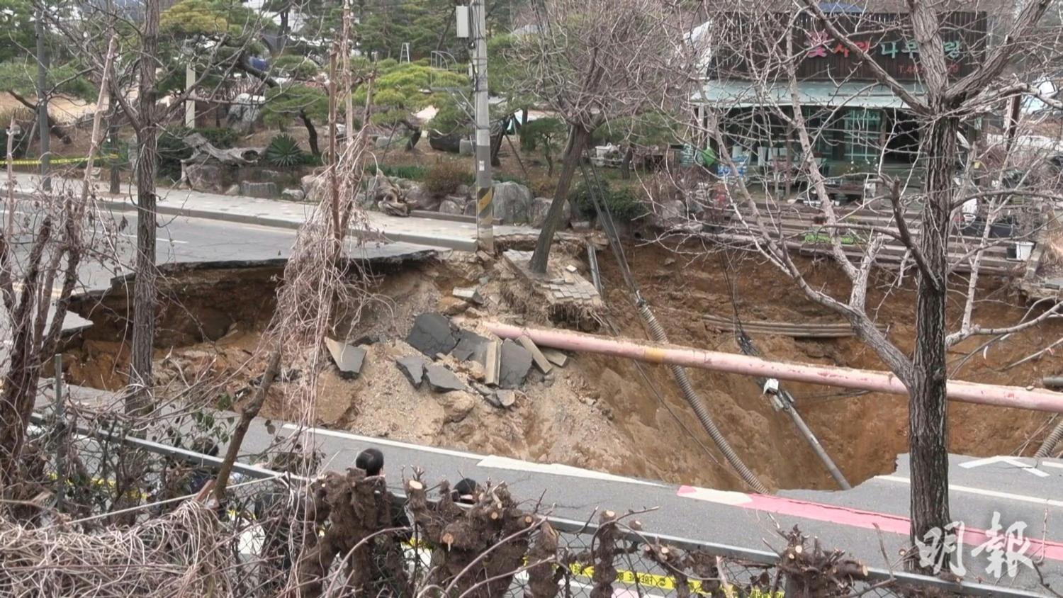 韓國首爾市東面江東區一條行車公路周一（24日）傍晚路陷，出現一個大窿。（法新社）