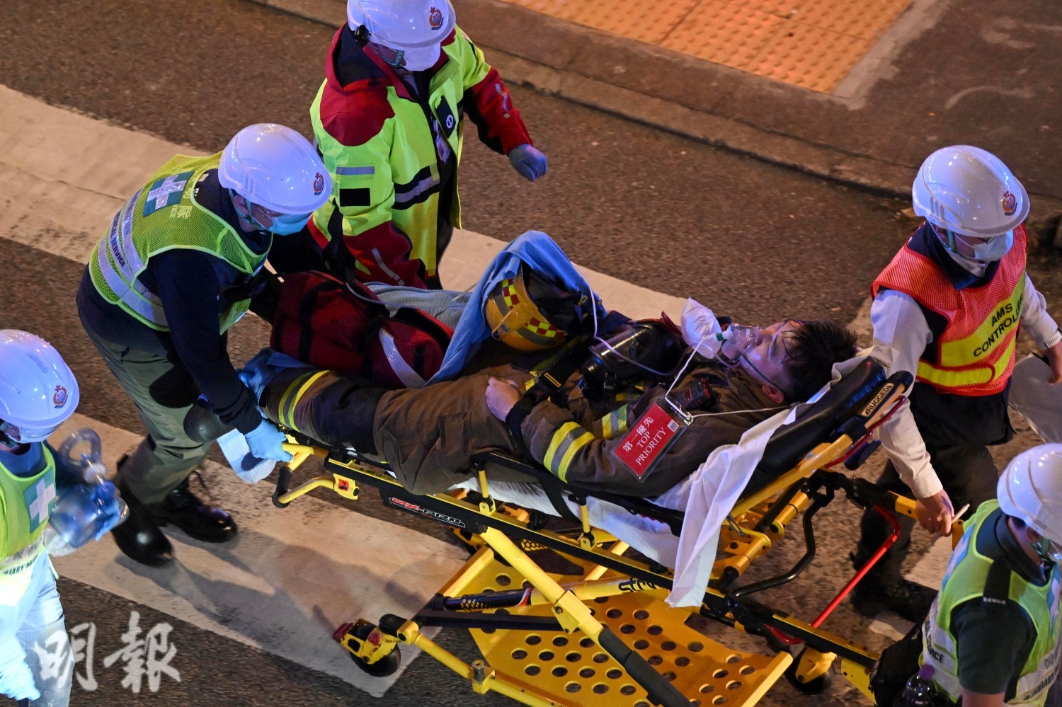 有消防員由醫療輔助隊擔架送院。(鍾林枝攝)