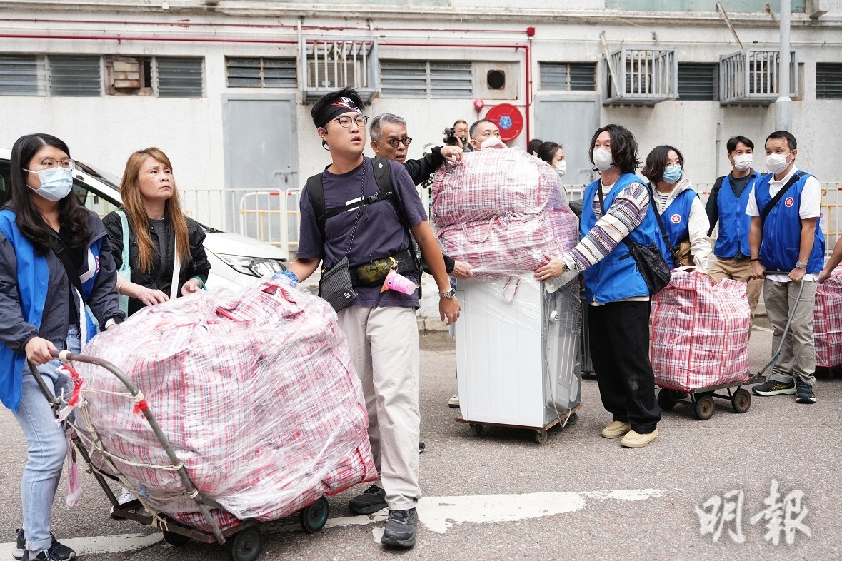 宏志閣居民今晨陸續返回寓所收拾個人物品，有關愛隊在場協助。（賴俊傑攝）