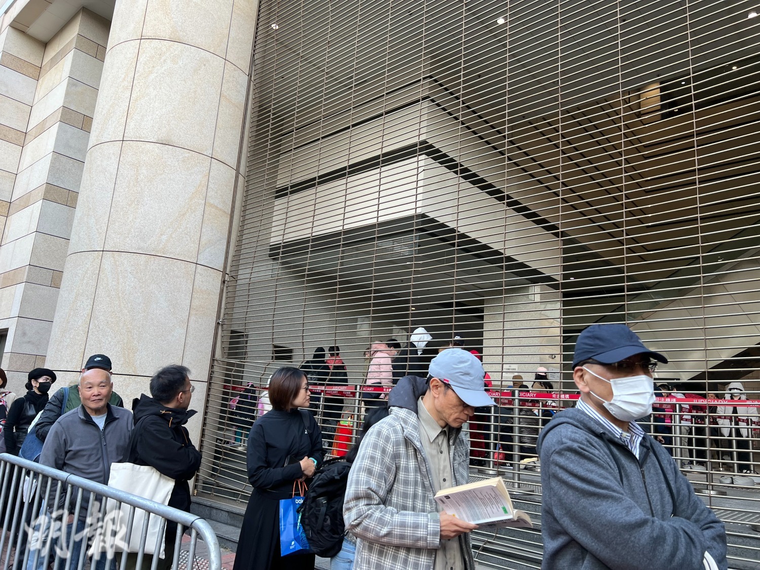 有市民排隊時看書打發時間。（房伊媚攝）