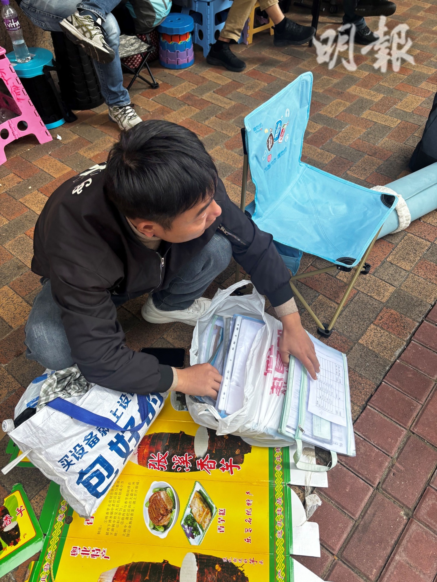 有操普通話的排隊者向記者展示一個膠袋，內有數十份內地駕駛者填寫的免試簽發香港駕照申請表。（孫澤芳攝）