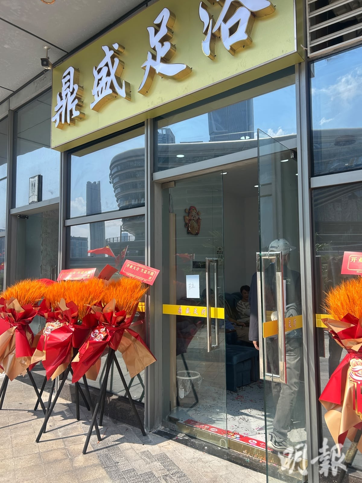 商場二樓則開有多家足浴按摩店及一間牙醫診所，現場人來人往，足浴店及診所的推銷人員均身著紅色橫幅在店外派傳單，有推銷人員直言今日人流「比之前多了好多」。（蔡宛均攝）