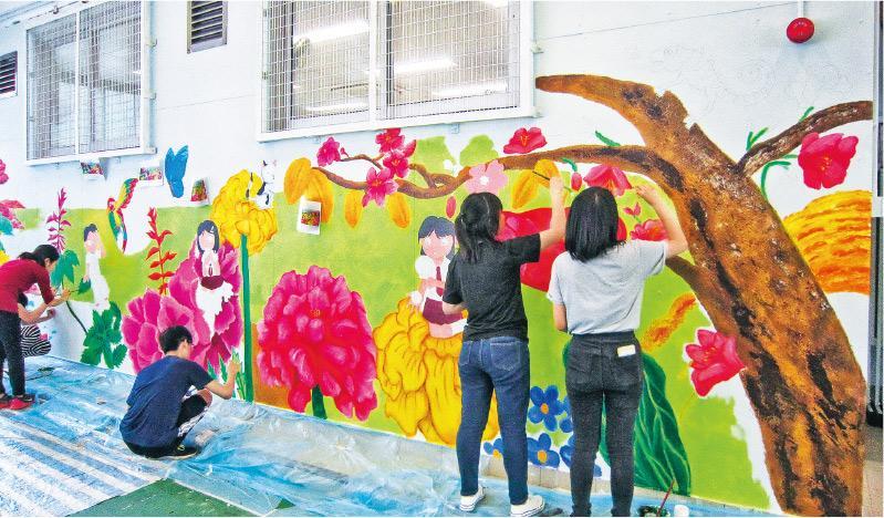 學校作畫——畫室負責人林小姐表示，受邀到學校辦壁畫工作坊時，需動員4至5名畫師教授教師和學生畫壁畫。（受訪者提供）