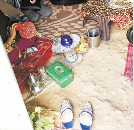 沙漠薄荷茶——帳篷內坐着一名女子，面前放了小水煲，還有一個小小泥爐灶和一隻銀閃閃的摩洛哥茶壺。（作者提供）