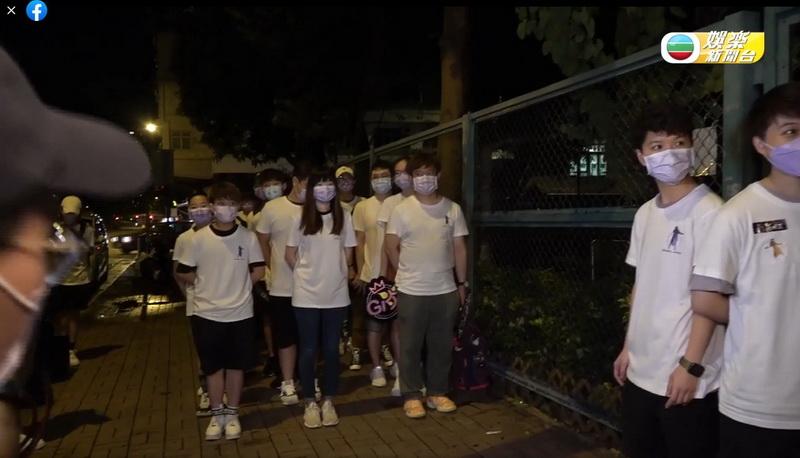 炎明熹的粉絲全部穿上白衫，沒表情地在場外3個一排列陣。（TVB娛樂新聞台facebook片段截圖）