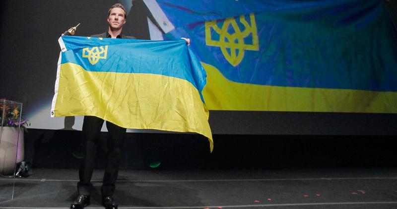 班尼狄甘柏貝治領獎不忘烏克蘭，在台上展示烏國國旗以示支持。（SBIFF Twitter圖片）