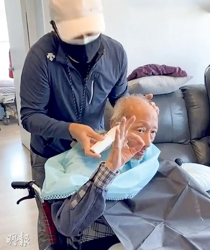 兒子變身理髮師，余子明對着鏡頭做OK手勢。（網上圖片）