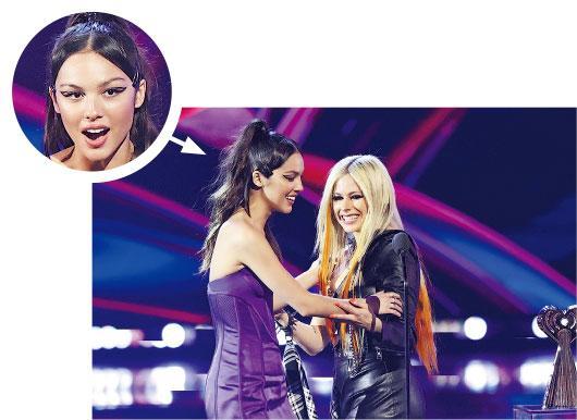 加拿大女歌手 Avril Lavigne（右）頒發年度女歌手獎給Olivia Rodrigo（左）。（路透社）