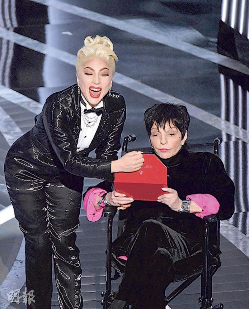 Lady Gaga（左）與坐在輪椅出場的金像影后麗莎明妮莉頒發最佳電影獎。（法新社）