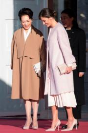 2018年11月28日，國家主席習近平夫人彭麗媛（左）與西班牙王后萊蒂西亞（右）出席活動時，均以大褸造型配clutch和高跟鞋。（法新社）